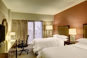 利马Sheraton Lima Historic Center的酒店客房设有两张床和电视。