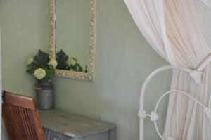 KounopetraMezzao的配有桌子、镜子和窗帘的房间