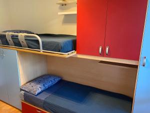 普拉托Accanto a Firenze的小房间设有两张双层床和红色橱柜