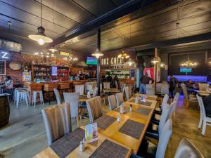 开普敦Visually Stunning apartment的一间带木桌椅的餐厅和一间酒吧