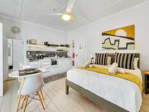开普敦Visually Stunning apartment的一间白色卧室,配有一张大床和一个厨房