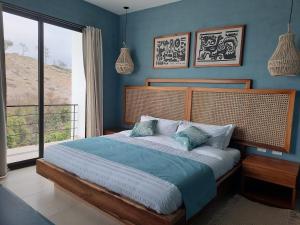哈马Jama Campay - Homes Resort & Spa的一间卧室配有一张蓝色墙壁的床和一扇窗户