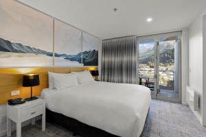 皇后镇美景酒店的酒店客房设有一张大床和一个阳台。