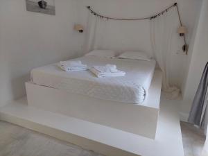 阿吉亚玛丽娜Golden Star Praxitelous的白色的床,配有白色的床单和毛巾
