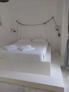 阿吉亚玛丽娜Golden Star Praxitelous的卧室配有一张带挂床架的白色床