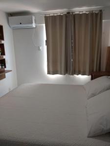纳塔尔Verano Praia Ponta Negra AP 1401的卧室配有白色的床和窗户。