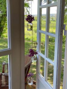 StenstrupHyggelig country Lodge的门,窗户上装有紫色花朵