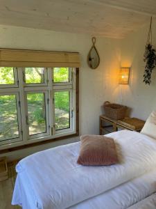 StenstrupHyggelig country Lodge的卧室设有白色大床和窗户。