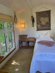 StenstrupHyggelig country Lodge的一间卧室设有两张床、一张桌子和窗户。