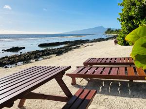 莫雷阿moorea temae bungalow lory bord de mer的海边沙滩上的两张野餐桌