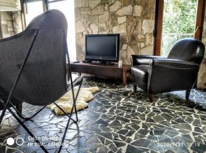 波德戈里察Holiday home Haustor with Skadar lake view的客厅配有两把椅子和电视