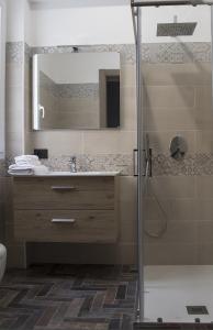 兰佩杜萨Incanto Luxury Rooms的带淋浴、盥洗盆和镜子的浴室