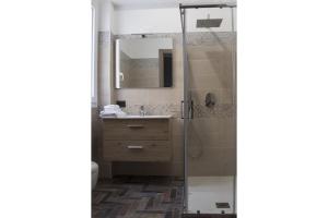 兰佩杜萨Incanto Luxury Rooms的带淋浴和盥洗盆的浴室