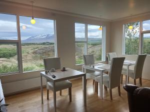 阿克雷里Glæsibær 2 Guesthouse and horsefarm的用餐室设有桌椅和窗户。