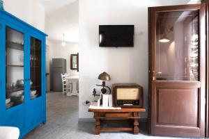 ArmungiaCasa tipica nel borgo antico的一间设有蓝色门的房间和墙上的电视