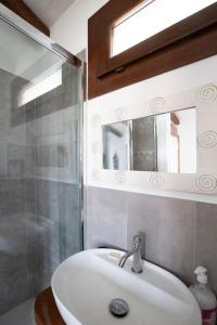 ArmungiaCasa tipica nel borgo antico的一间带水槽、淋浴和镜子的浴室