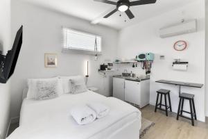 斯科茨Scottsdale OT Classic BoHo Micro Studio的白色卧室设有白色的床和厨房