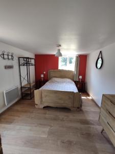 蓬托尔松Aux Berges du Mont的一间卧室设有一张床和红色的墙壁