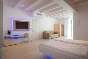 卡奥莱Unico Hotel Caorle的白色的客房配有床和电视。
