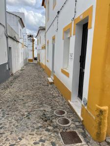 埃武拉HOUSE NEXT TO THE THEATER的一条空洞的黄色和白色的小巷