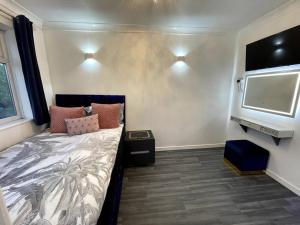 Trimley HeathChic 2 Bedroom Flat的一间卧室配有一张床和一台平面电视