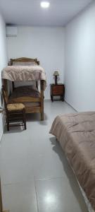派桑杜Apartamento Romian的一间卧室配有一张床、一把椅子和一张桌子
