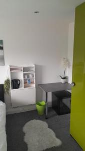 曼彻斯特Posyrooms的客房设有书桌、桌子和绿门。
