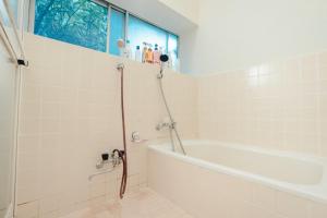 气仙沼市SLOW HOUSE kesennuma - Vacation STAY 31901v的一间带浴缸和淋浴的浴室,并设有一个窗户
