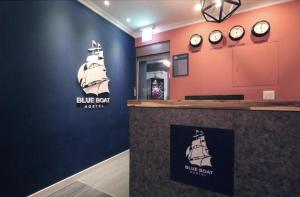 全州市Blueboat Hostel Jeonju的墙上挂着钟的蓝色条形