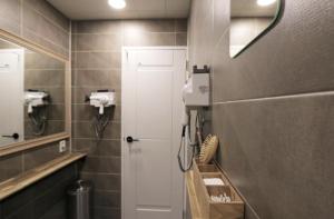 全州市Blueboat Hostel Jeonju的浴室设有白色门和镜子