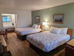 圣安东尼Henry's Fork Inn的酒店客房设有两张床和窗户。