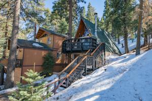 大熊湖Bear Mountain Summit - A-frame nestled in the oaks and pines!的雪中树林里的小木屋