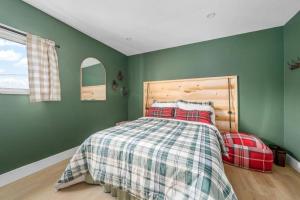 皮克顿Urban Cabin - Downtown Picton的一间卧室设有绿色的墙壁和一张带铺着地毯的床。