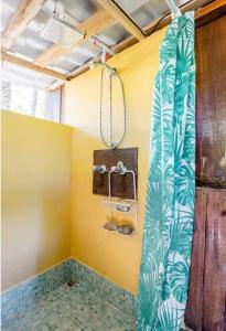 乌维塔Luminosa Uvita Hostel的一间设有黄色墙壁淋浴的浴室
