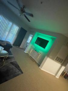 奥兰多Loftly Luxury Modern Oasis 2BR 2BA apartment Windermere FL, near Disney, Universal Studios, Magic Kingdom, Pool, Gym, Patio, free cable, wifi, free parking, gym, Alexa, lake, gated community, spacious closets, close to shops and mall的客厅的墙壁上拥有绿灯