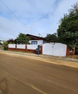 埃尔基斯科Casa en condominio cerca de la playa El Quisco Norte的街道旁的白色围栏房子
