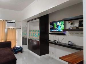 大雅台B123 Unit 1852 Prime Residences Tagaytay的客厅配有沙发和墙上的电视