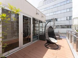 横滨Tabist MAYUDAMA CABIN的坐在大楼阳台的椅子