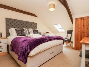 圣奥斯特尔Wheal Prosper的一间卧室配有一张大床和紫色毯子