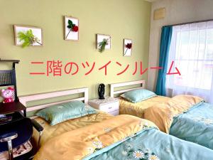 富良野PENSION YunShuiYao雲水瑶民宿的墙上写着书的客房内的两张床