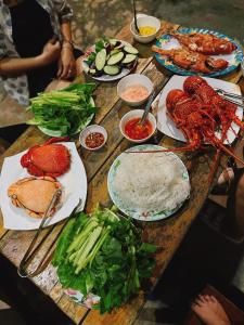 惹岛Lộc An Lý Sơn Motel的一张木桌,上面放着食物盘