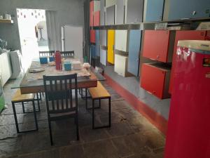 马塞约"LE CHAT QUI PECHE" Hostel a 150 metros da PRAIA de PAJUCARA的厨房配有桌椅和橱柜。