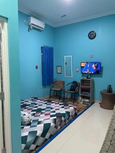 茂物Bu Sur Homestay的蓝色的房间,配有床和电视