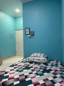 茂物Bu Sur Homestay的一间卧室配有一张蓝色墙壁的床