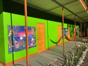 Dos BrazosYejos的绿色的建筑,上面有吊床和画作