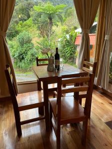 巴尼奥斯La Casa de Martin的桌椅、一瓶葡萄酒和窗户