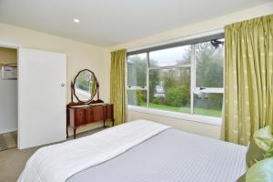 基督城Charlesworth Villa - Christchurch Holiday Homes的一间卧室设有一张床和一个大窗户