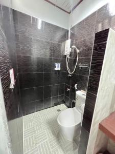 Sungai KolokThe Sekret Hotel的黑色瓷砖浴室设有卫生间和淋浴。