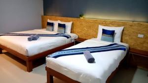 Sungai KolokThe Sekret Hotel的两张位于酒店客房的床,配有毛巾