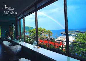 大岛Hotel MOANA絶景オーシャンビューカフェラウンジ的阳台享有海景,配有彩虹